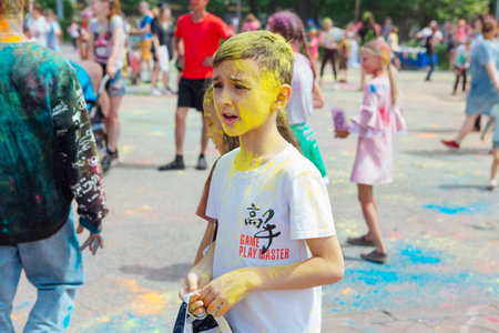 Novokuznetsk, Kemerovo region, Russia - June 12, 2022 :: Boy with colorful face painted with holi powder having fun outdoors.のeditorial素材