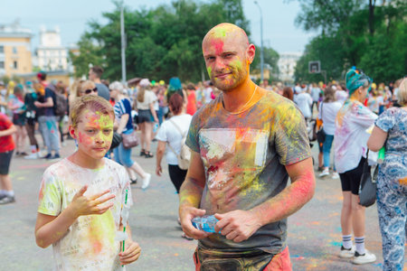Novokuznetsk, Kemerovo region, Russia - June 12, 2022 :: Boys with colorful faces painted with holi powder having fun outdoors.のeditorial素材