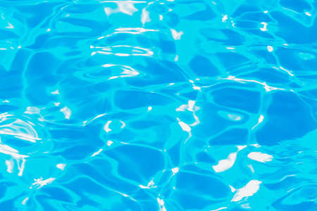 Swimming pool water surface with sparkling light reflections. aqua background.