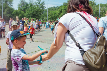 Novokuznetsk, Kemerovo region, Russia - June 12, 2022 :: Mother and son with colorful faces painted with holi powder having fun outdoors.のeditorial素材