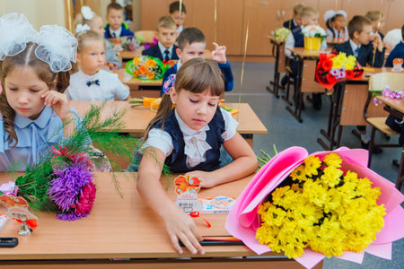 First-grade students and teacher are in school classroom at first lesson. The day of knowledge in Russia.のeditorial素材