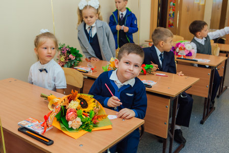 First-grade students and teacher are in school classroom at first lesson. The day of knowledge in...