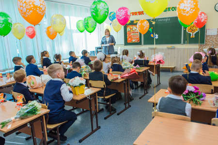 NOVOKUZNETSK, KEMEROVO REGION, RUSSIA - SEP, 1, 2021: First-grade students and teacher are in school classroom at first lesson. The day of knowledge in Russia.の写真素材