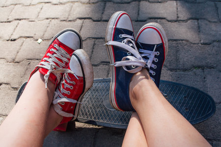 Red and blue sneakers shoes on a feet. Sneakers shoes Couple. copyspace.