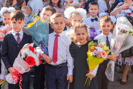 Meeting with the first-grade pupils and teacher at schoolyard. The day of knowledge in Russia.のeditorial素材