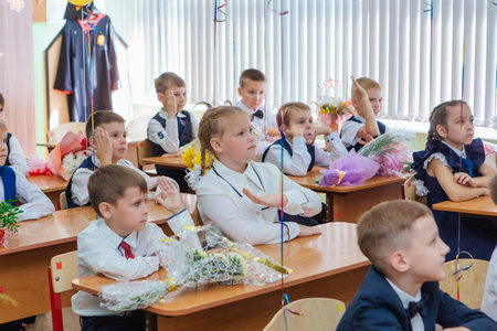 First-grade students and teacher are in school classroom at first lesson. The day of knowledge in Russia.のeditorial素材