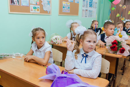 First-grade students and teacher are in school classroom at first lesson. The day of knowledge in Russia.のeditorial素材