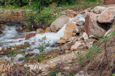 Fast mountain river running among large stonesの写真素材