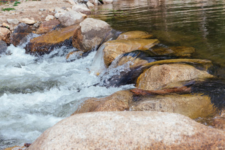 Fast mountain river running among large stonesの写真素材