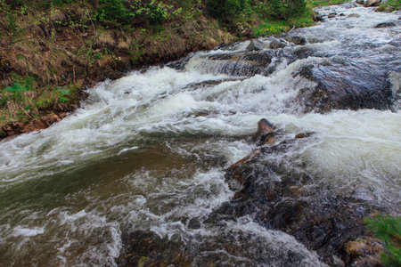 Fast mountain river running among large stonesの写真素材