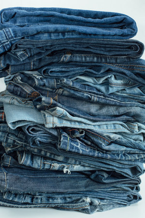 Stack of a stack of old jeans various shades of blue jeans. Denim jeans texture. Denim background texture for design. Canvas denim texture. Blue denim background.の写真素材