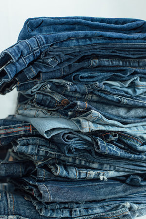 Stack of a stack of old jeans various shades of blue jeans. Denim jeans texture. Denim background texture for design. Canvas denim texture.の写真素材