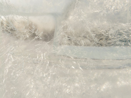 Ice texture background close up. Textured cold frosty surface of ice block with frozen air bubbles.の写真素材