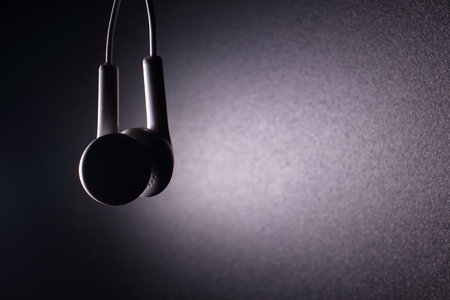 White earphone with violet light on dark backgroundの写真素材