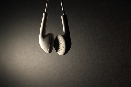 White earphone with brown light on dark backgroundの写真素材