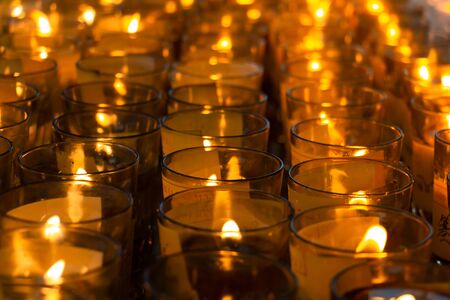Many candle light in glass burning in the darkの写真素材