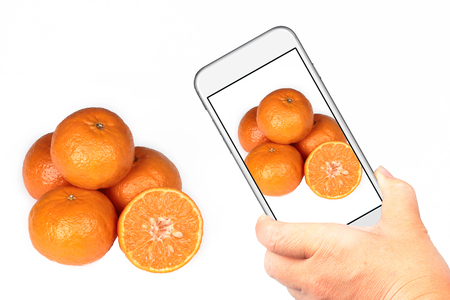 Friend using smart-phone to take photo oranges for share the social network.の写真素材