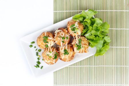 A dish of 6 big Takoyakis on bamboo sheet.の写真素材