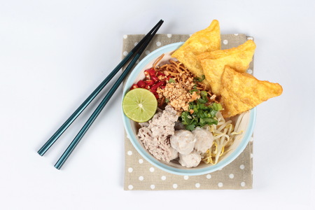 Crispy noodle in spicy sour soup as tom yam  topped with minced pork,meatball,wonton,chili and green...