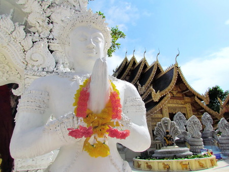 White blessing angel statue before buddhist building at Temple. North of Thailand.