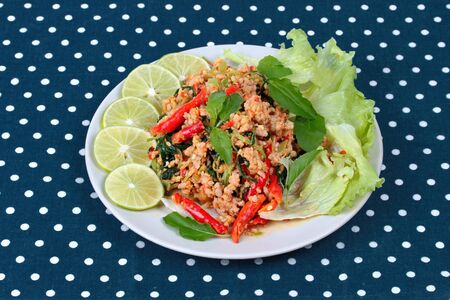 Fried spicy basil with minced pork topped sliced green lemon and and lettuce is top ten of popular Thai food.の写真素材