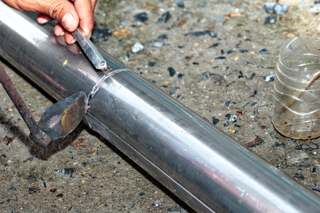 Aluminium gutter welding by using soldering copper with picnic gas:Technician is welding aluminium pipe by using soldering copper.の写真素材