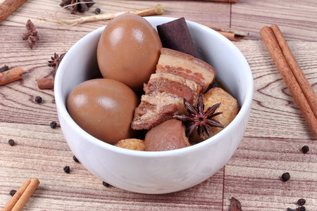 Thai Recipes : Stewed boiled egg with tofu and streaky pork ,call Khai Palo in Thai, take photo with herbs as Chinese star anise ,cinnamon,black pepper,cilantro roots and stems . Selective focus.の写真素材
