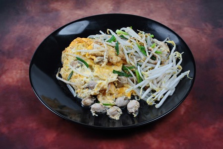Thai food,Fried egg and oyster with bean sprouts and shallot as Hoi Tod Khai in Thai served with chili sauce.の写真素材