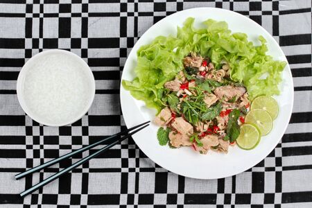 Rice gruel and spicy sour mixed herb salad with canned tuna  topped sliced green lemon and lettuce is popular Thai cuisineの写真素材