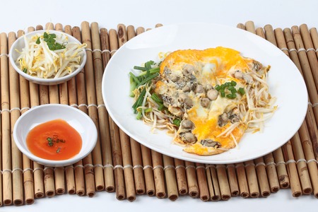 Fried oyster omelet with bean sprouts and shallot call Hoi Tod Khai in Thai served with chili sauce...