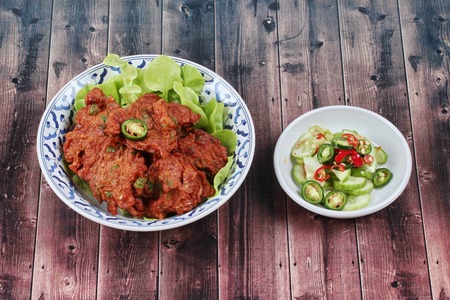 Thai recipe, Deep fired curried fish cake with lentils served with side dish as cucumber ,red chili...