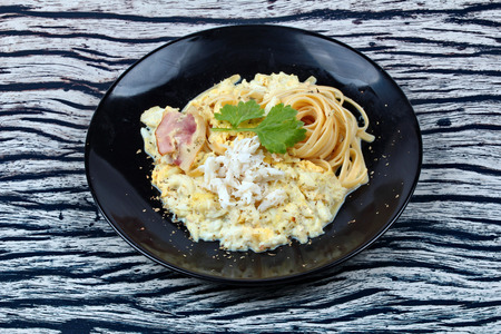 Spaghetti carbonara recipe with crab in black dish.の写真素材