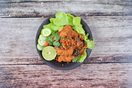 Thai food , Spicy sour fried chicken salad  call Yum Kai Zap in Thai topped sliced cucumber, lettuce and halve green lemon .の写真素材