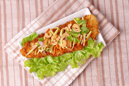 Spicy crispy deep-fried Dolly's fish salad with roll green mango call Dolly Yum Mamoung.の写真素材