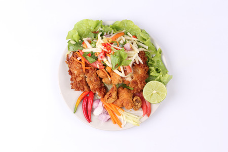 Spicy crispy deep-fried chicken salad with roll green mango call Kai Zap Yum Mamoung in Thai.の写真素材