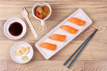 Salmon sushi,sushi nigiri with salmon, and side dish ( shoyu,sliced pickled ginger and wasabi ) served with Japanese yellow curry.の写真素材