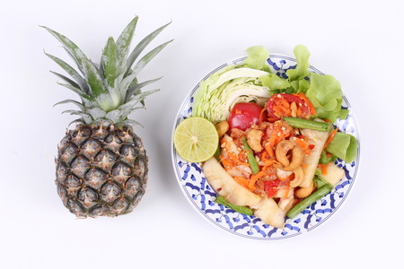 Thai food , Spicy and sour mixed vegetable salad with pineapple topped Green Oak ,sliced cabbage and halved green lemon .  And pineapple whole fruit.の写真素材