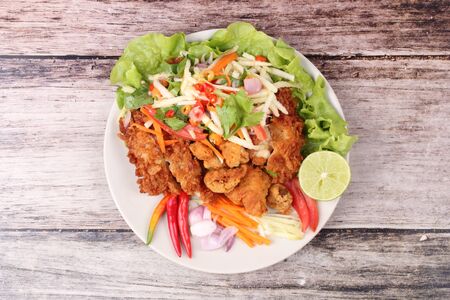 Spicy crispy deep-fried chicken salad with roll green mango call Kai Zap Yum Mamoung in Thai.の写真素材