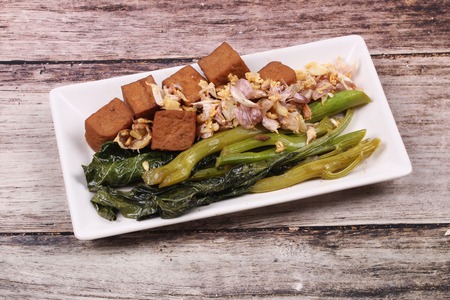 Fried kale with tofu in brown soup topped crispy garlic ,No meat.の写真素材