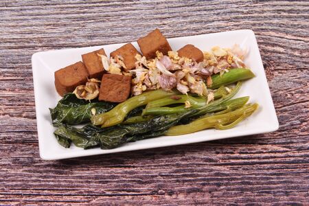 Fried kale with tofu in brown soup topped crispy garlic ,No meat.の写真素材