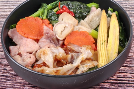 Thai popular food ,Fried big noodle topped Chinese kale and marinated pork in soup with carrot,corn ,mushroom and red chili call Sen Yai Pad Rad Nae in Thai.の写真素材