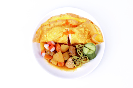 Thai Japanese food,Omelet Jasmine rice with Japanese curry, sliced cucumber,Crab stick and roasted green chili, served on white background.の写真素材