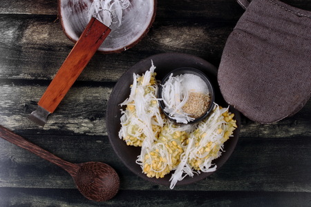 Thai popular dessert ,Streamed mung bean topped roll coconut  call Khanom Tau Pab in Thai, served with white sesame and sugar and kitchen equipment cookingの写真素材
