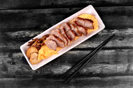 Homemade ,Omelet topped pork steak and grilled mixed mushroom in Japanese style.の写真素材