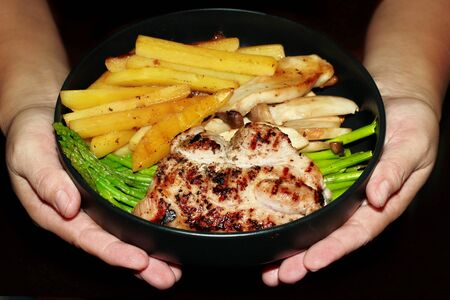 Pork steak with sliced carrot ,potato ,corn ,broccoli and cauliflower.の写真素材