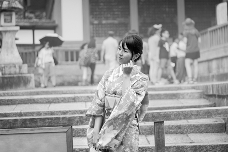 Kyoto,Japan-June 26,Women's kimonos post and smile for photo within Fushimi Inari shrine on June 26,2016 in Kyoto,Japan. Selective focus at wowan in Black and White style.のeditorial素材
