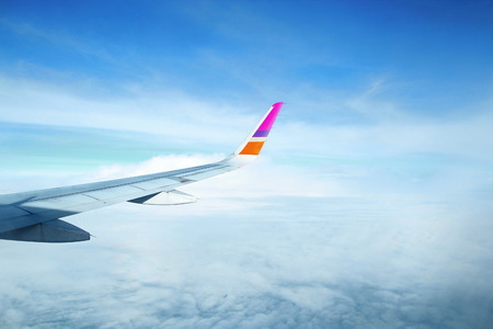 Take a Photo from plane of above the cloud in sky and wing of airplane.の写真素材