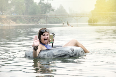 Vang Vieng,Laos, 29 March 2014,Tourists sit ring to cruise along Song River  and greeted with a refreshing smile.のeditorial素材