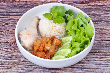 Popular Thai recipe, Streamed oily Jasmine rice and streamed chicken call as Hainanese chicken rice and deep fried chicken topped mixed vegetable.の写真素材