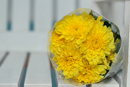 Colorful yellow flowers bouquet is a combination rests on white wood. Selective focusの写真素材